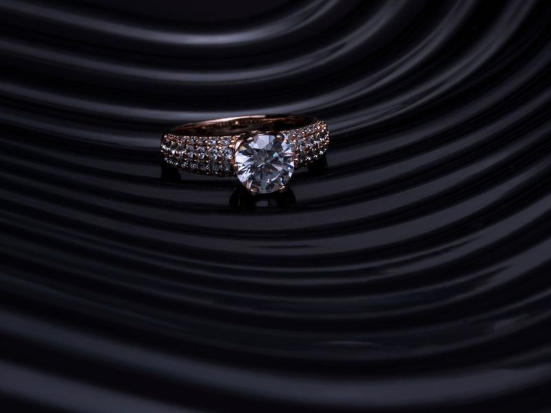 Solitaire diamond engagement ring on a dark surface
