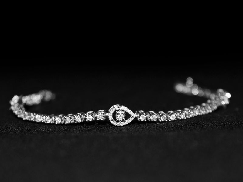 Diamond tennis bracelet on a dark surface